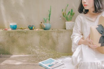 Photography of Woman Sitting Holding Straw Hat