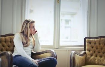 Photography of Woman Sitting on Chair Near Window