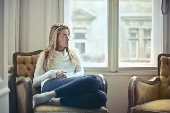 Photography of Woman Sitting on Chair Near Window
