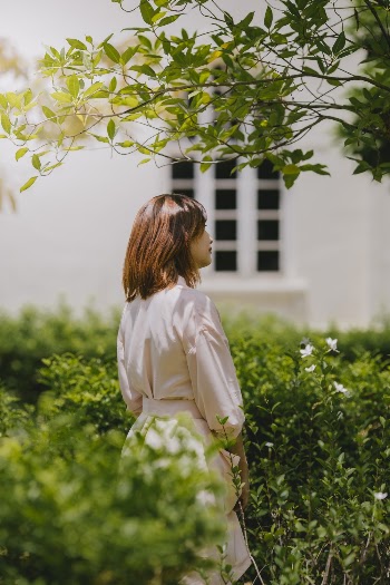 Photography of Woman Standing Beside Green Plants