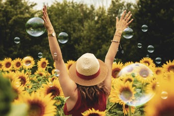Photography of Woman Surrounded by Sunflowers