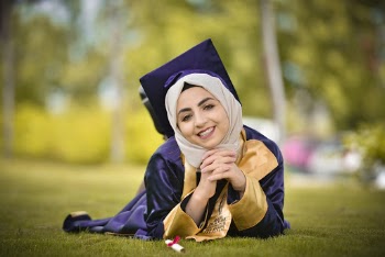 Photography of Woman Wearing Graduation Toga Lying on Green Lawn Grass