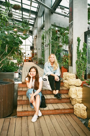 Photography of Women Sitting on Wooden Stairs