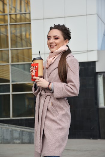 Photoof Smiling Woman Holding a Plastic To Go Cup and Candy Packet