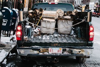 pickup truck loaded by firewood while parked on concrete roadway