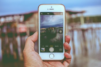 Picture Holding Iphone Taking Photo on House on Beach