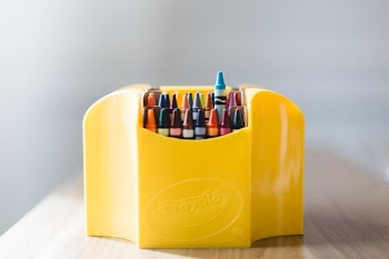 pile of assorted-color crayons in yellow organizer