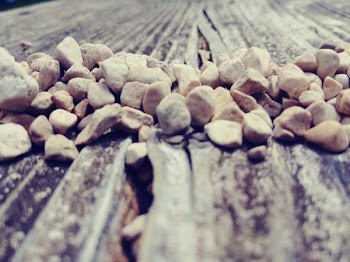 Pile of Beige Stone on Brown Wood Surface