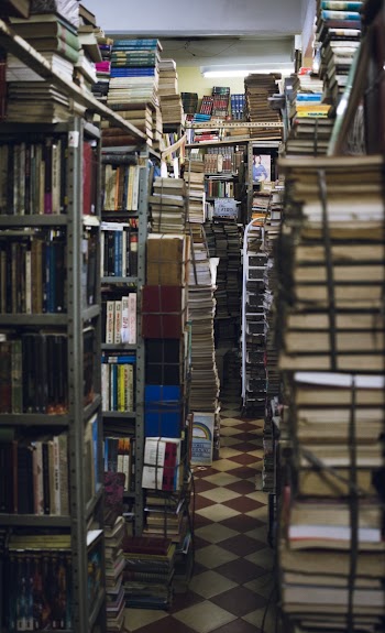 Pile of Books on Gray Metal Rack