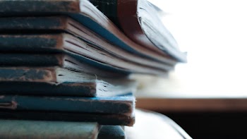 Piled Soft-bound Books on Table