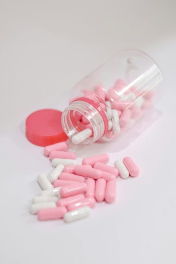Pink and White Capsule Pills in a Container