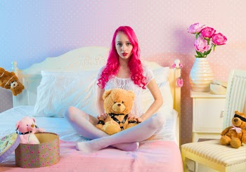 Pink Long Haired Woman Sitting on Double Bed With Bear Plsuh Toy at Daylight