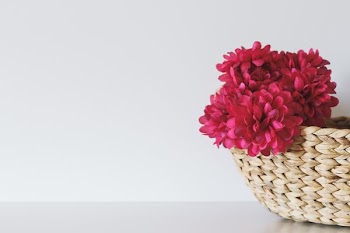 pink petaled flower inside brown wicker basket