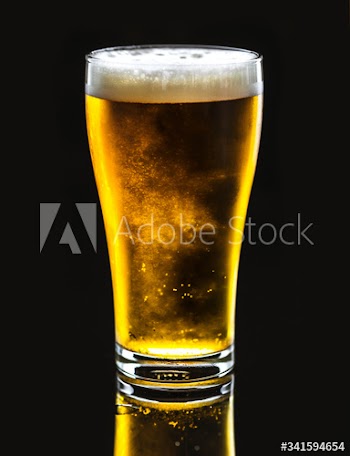 Pint of cold delicous draught beer on black background