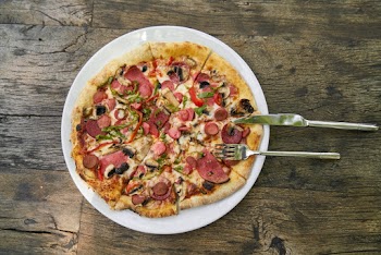 Pizza on Plate With Slicer and Fork