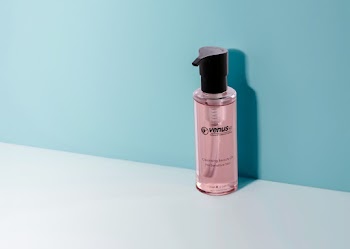 Plastic Bottle Placed on White Platform With Blue Wall