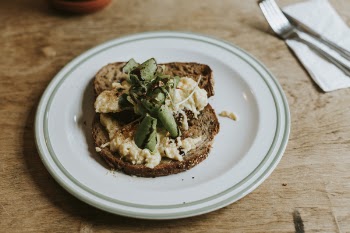 Plate with a Slice of Brown Bread With Herbs and Cheese