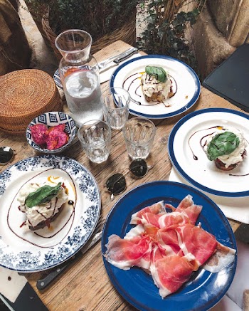 Plates of Food With Drinking Glasses on Table