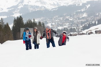Playful family in snowy mountain field