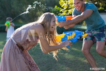 Playful family with squirt guns in backyard