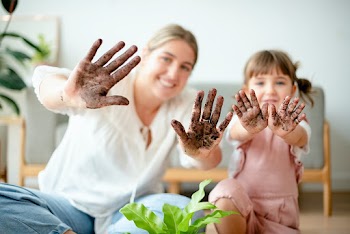 Playful mom and kid potting plant at home | Free stock photo | High Resolution image
