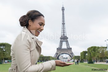 Playful woman pretending to hold Eiffel Tower in palm, Paris, France