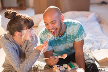 Playful young couple sharing sushi
