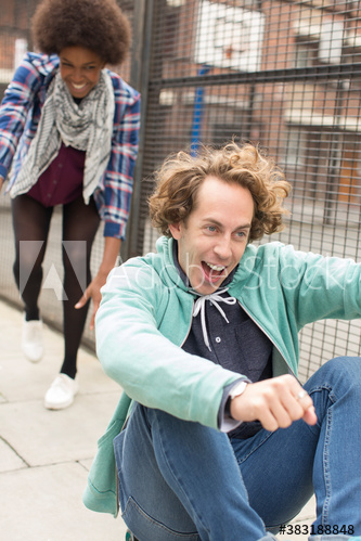 Playful young friends on city sidewalk