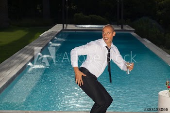Playful young man dancing at poolside party