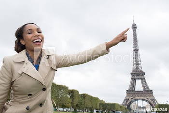Playful young woman pointing at Eiffel Tower, Paris, France