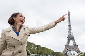 Playful young woman reaching for Eiffel Tower, Paris, France