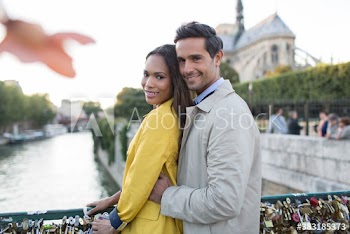 Portrait affectionate couple hugging on Pont des Arts, Paris, France