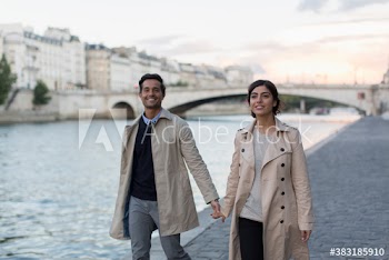 Portrait affectionate couple walking along Seine River, Paris, France