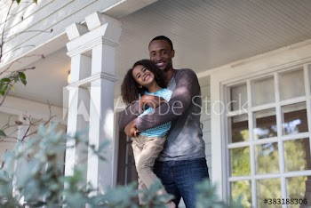 Portrait affectionate father and daughter hugging on front porch