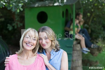 Portrait affectionate mother and daughter with family at treehouse