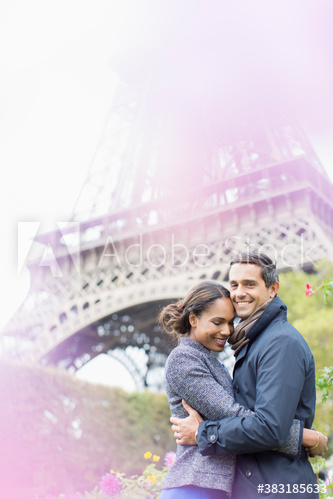 Portrait affectionate young couple hugging in front of Eiffel Tower, Paris