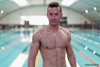 Portrait athletic male swimmer at indoor swimming pool