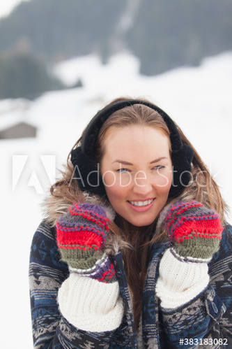 Portrait beautiful young woman in warm clothing in snow