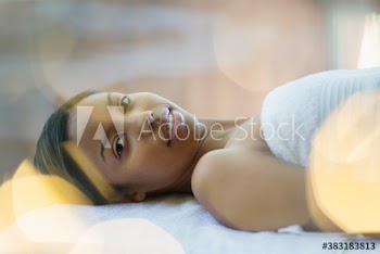 Portrait beautiful young woman relaxing on spa massage table