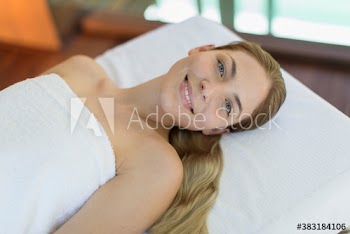 Portrait beautiful young woman relaxing on spa massage table