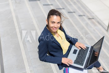 Portrait businesswoman using laptop on sunny steps