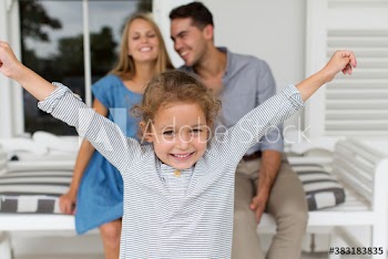 Portrait carefree girl with parents on patio