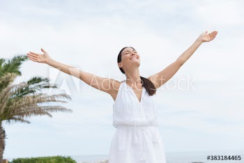 Portrait carefree woman with arms outstretched on ocean patio