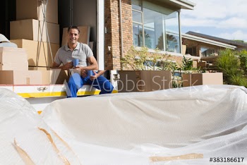 Portrait confidant male mover with coffee at back of moving van