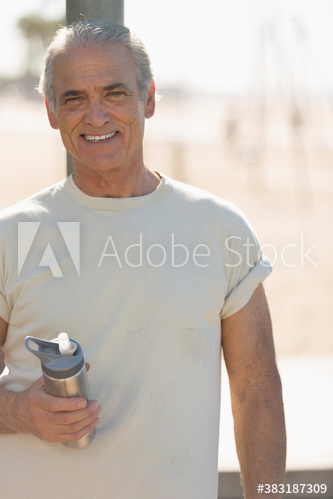Portrait confident active senior man with water bottle