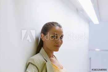 Portrait confident beautiful corporate businesswoman leaning against wall