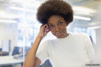 Portrait confident beautiful young businesswoman with afro in office