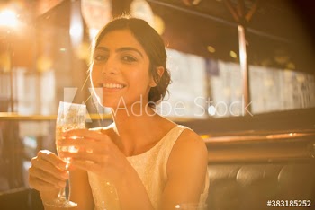 Portrait confident beautiful young woman drinking champagne in restaurant