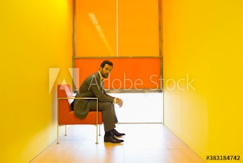 Portrait confident businessman in modern yellow office