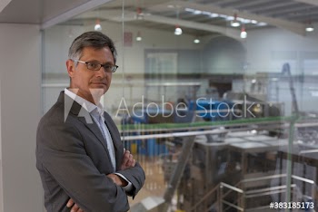 Portrait confident businessman supervising factory floor
